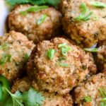 Stacked Thai Green Curry Shrimp Cakes garnished with cilantro leaves.