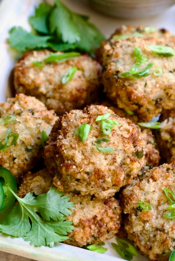 Stacked Thai Green Curry Shrimp Cakes garnished with cilantro leaves.