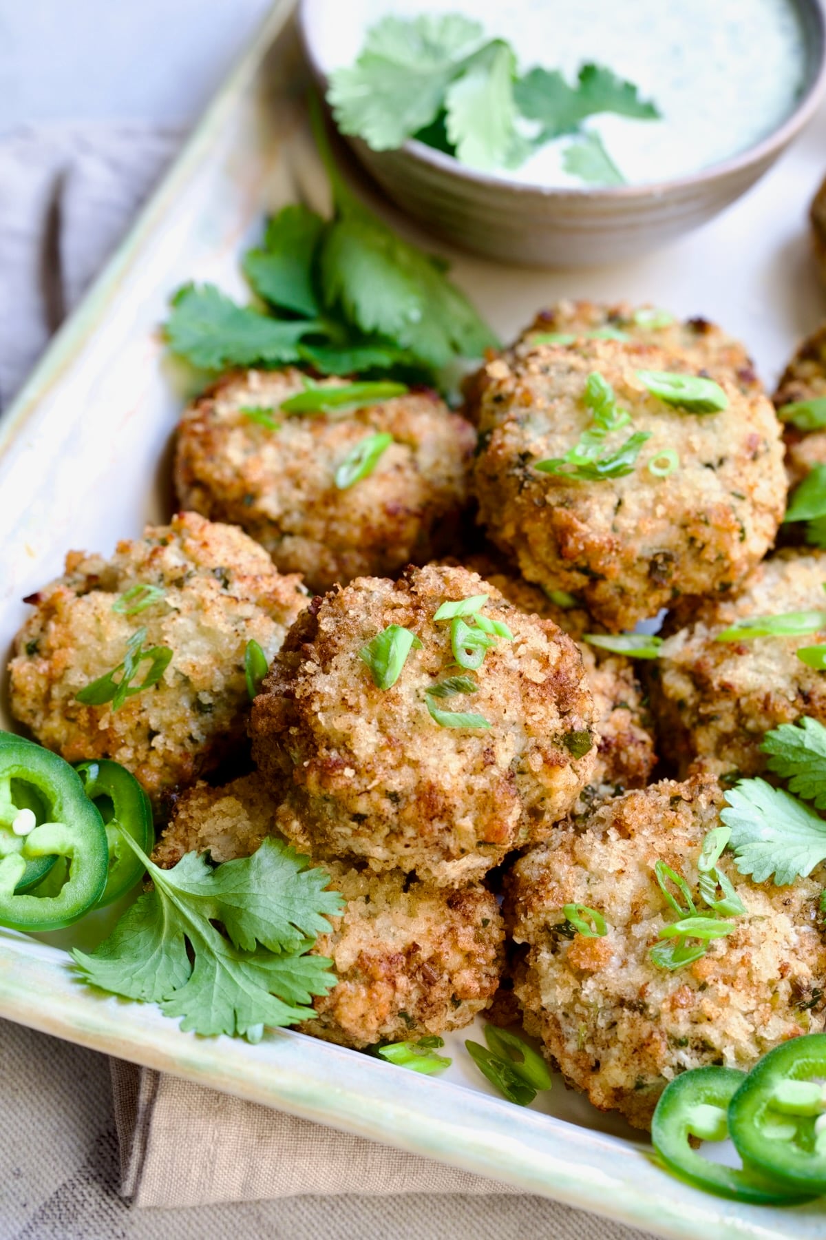 Stacked Thai Green Curry Shrimp Cakes garnished with cilantro leaves.