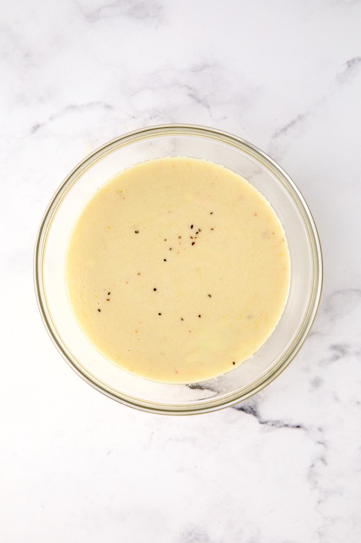 Lemon salad dressing in glass bowl.