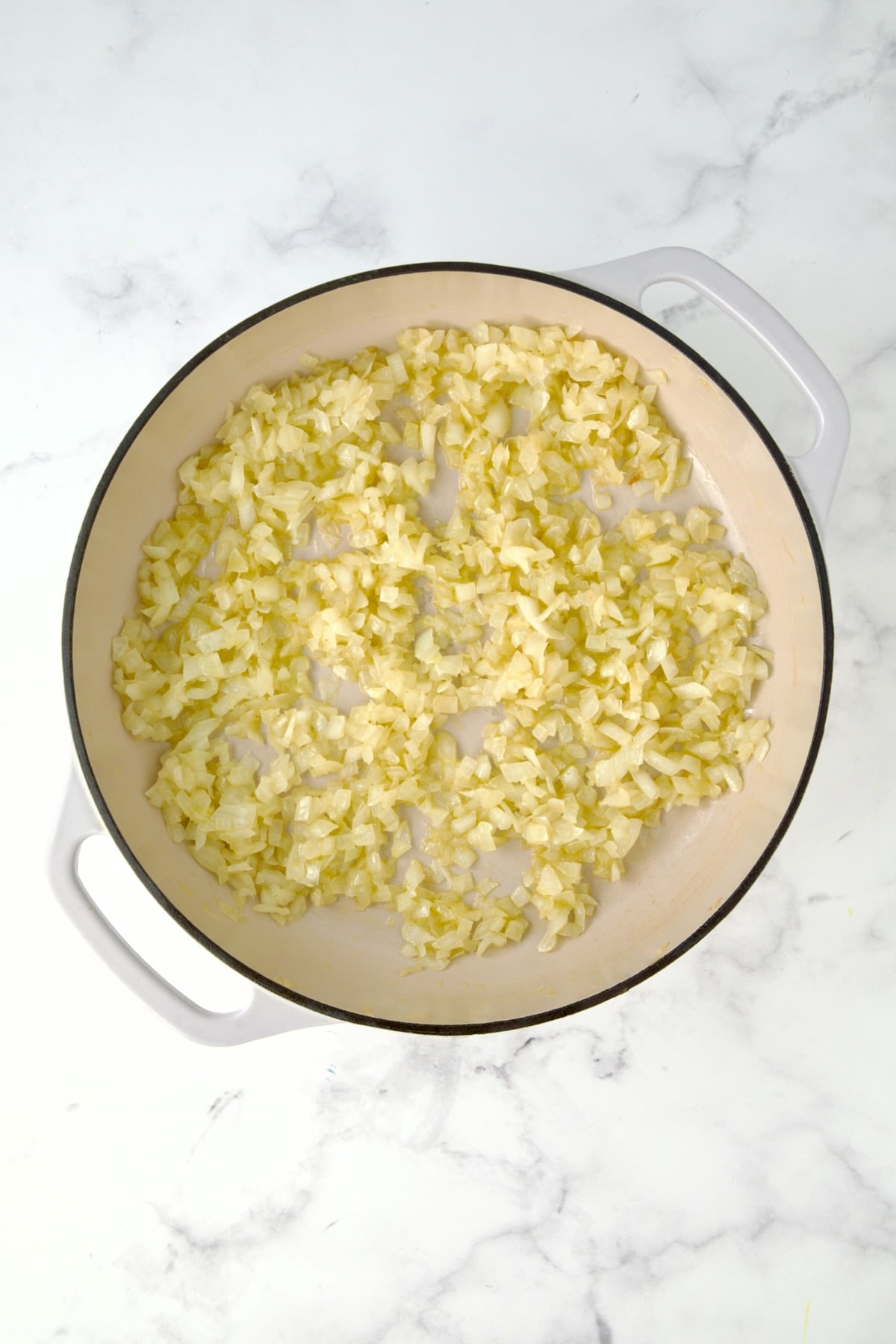 Cooked onions in white enamel cast iron skillet.