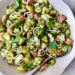 Herb and Vinegar Potato Salad in earthenware bowl with serving fork.