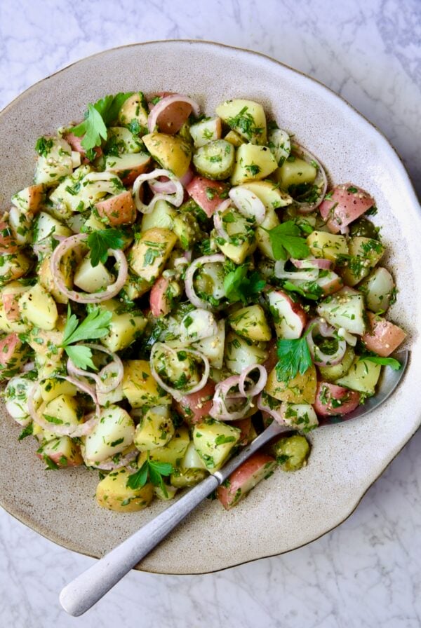 Herb and Vinegar Potato Salad in earthenware bowl with serving fork.