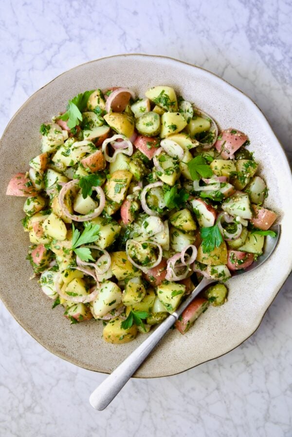 Herb and Vinegar Potato Salad in earthenware bowl with serving fork.