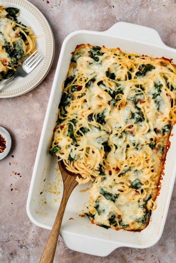 Pasta Frittata in white rectangular baking dish with a piece removed to a white plate.