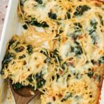 Close-up of frittata with wooden spoon lifting a piece out.