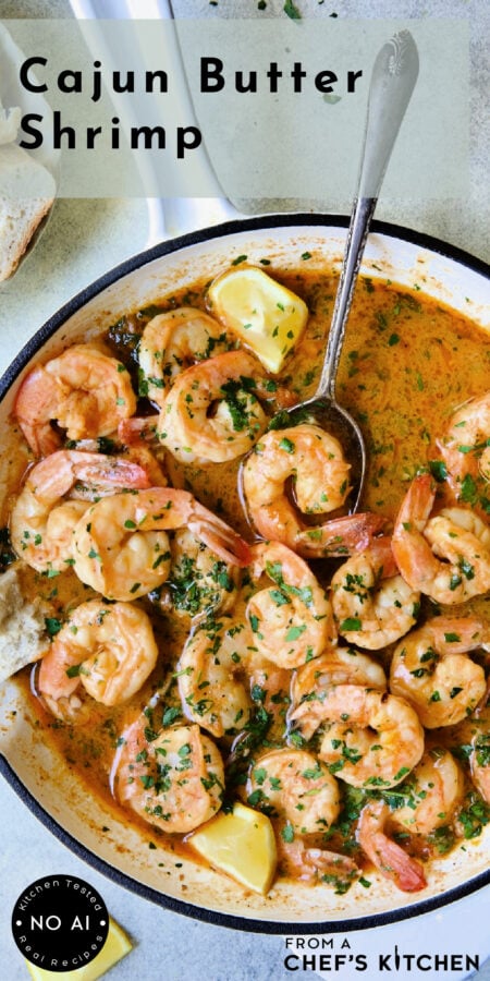 Pinterest graphic for Cajun Butter Shrimp showing it in a white nonstick skillet with spoon scooping up one shrimp.