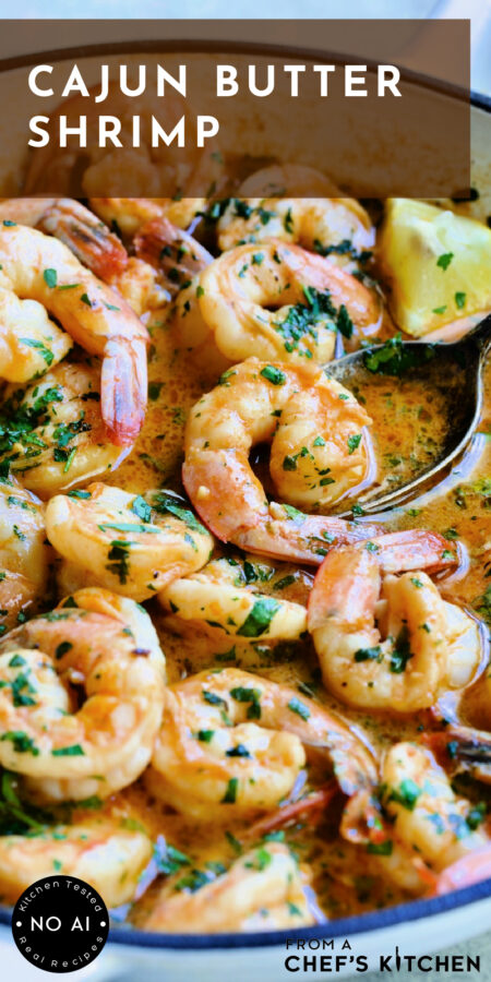 Pinterest graphic for Cajun Butter Shrimp showing it in a white nonstick skillet with spoon scooping up one shrimp.