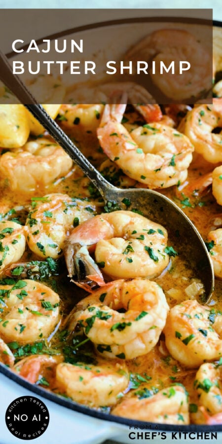Pinterest graphic for Cajun Butter Shrimp showing it in a white nonstick skillet with spoon scooping up one shrimp.