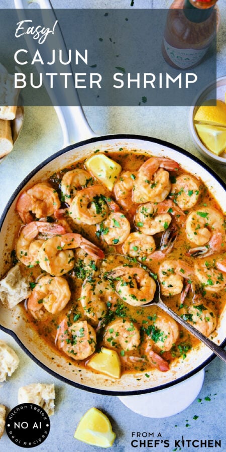 Pinterest graphic for Cajun Butter Shrimp showing it in a white nonstick skillet with spoon scooping up one shrimp.