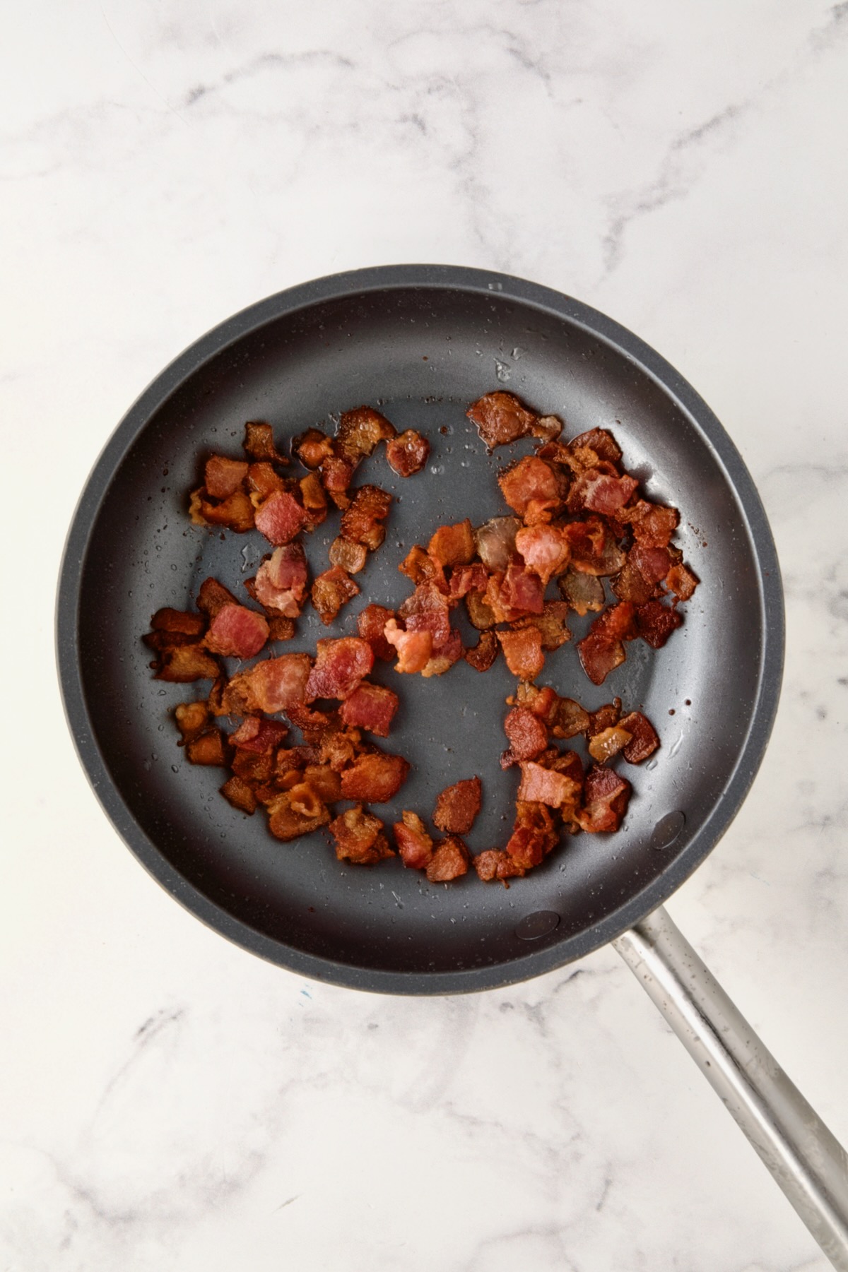Cooked diced bacon in nonstick skillet.