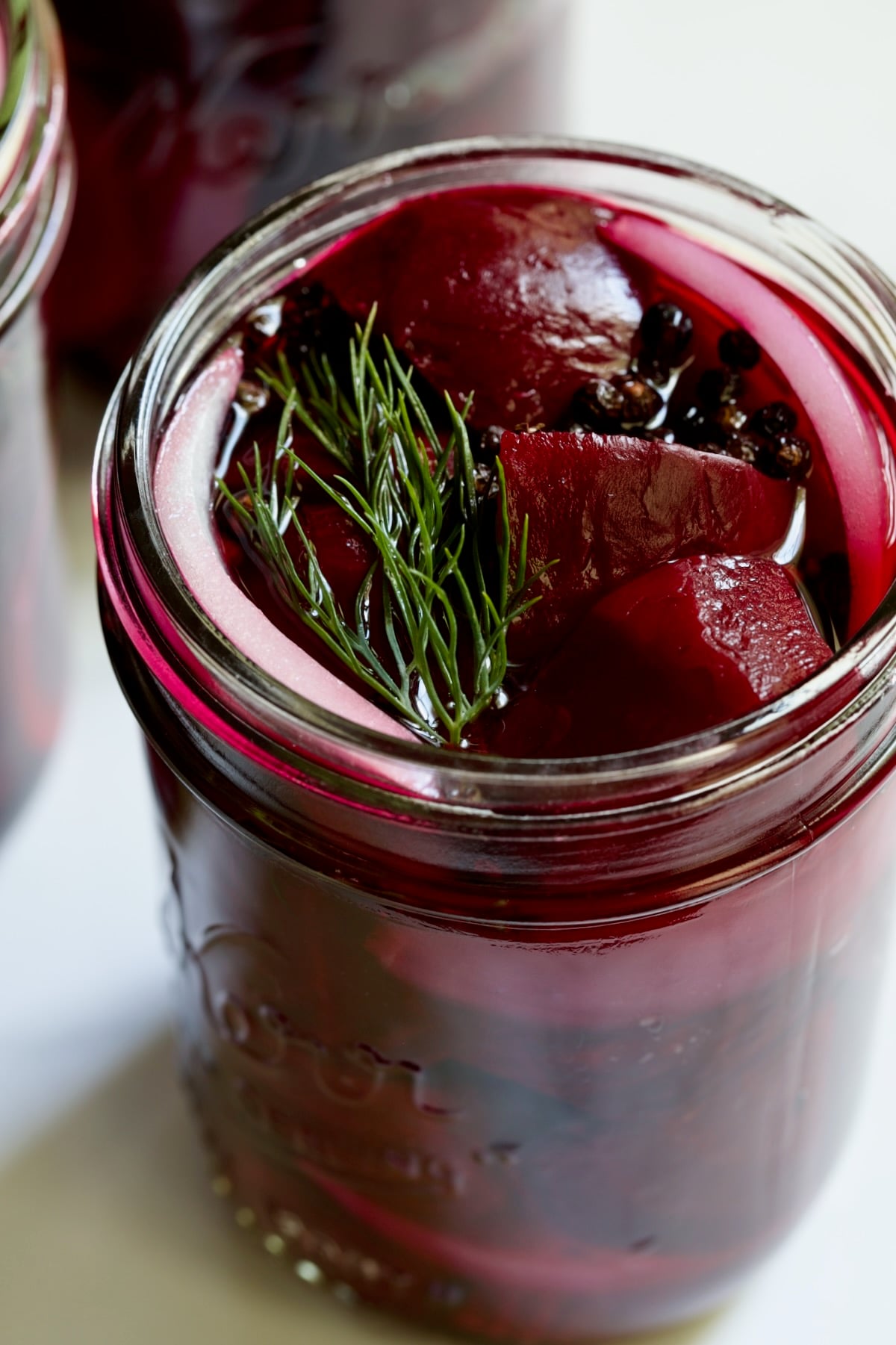 Fully filled pint jar with beets, dill, red onion and black peppercorns.
