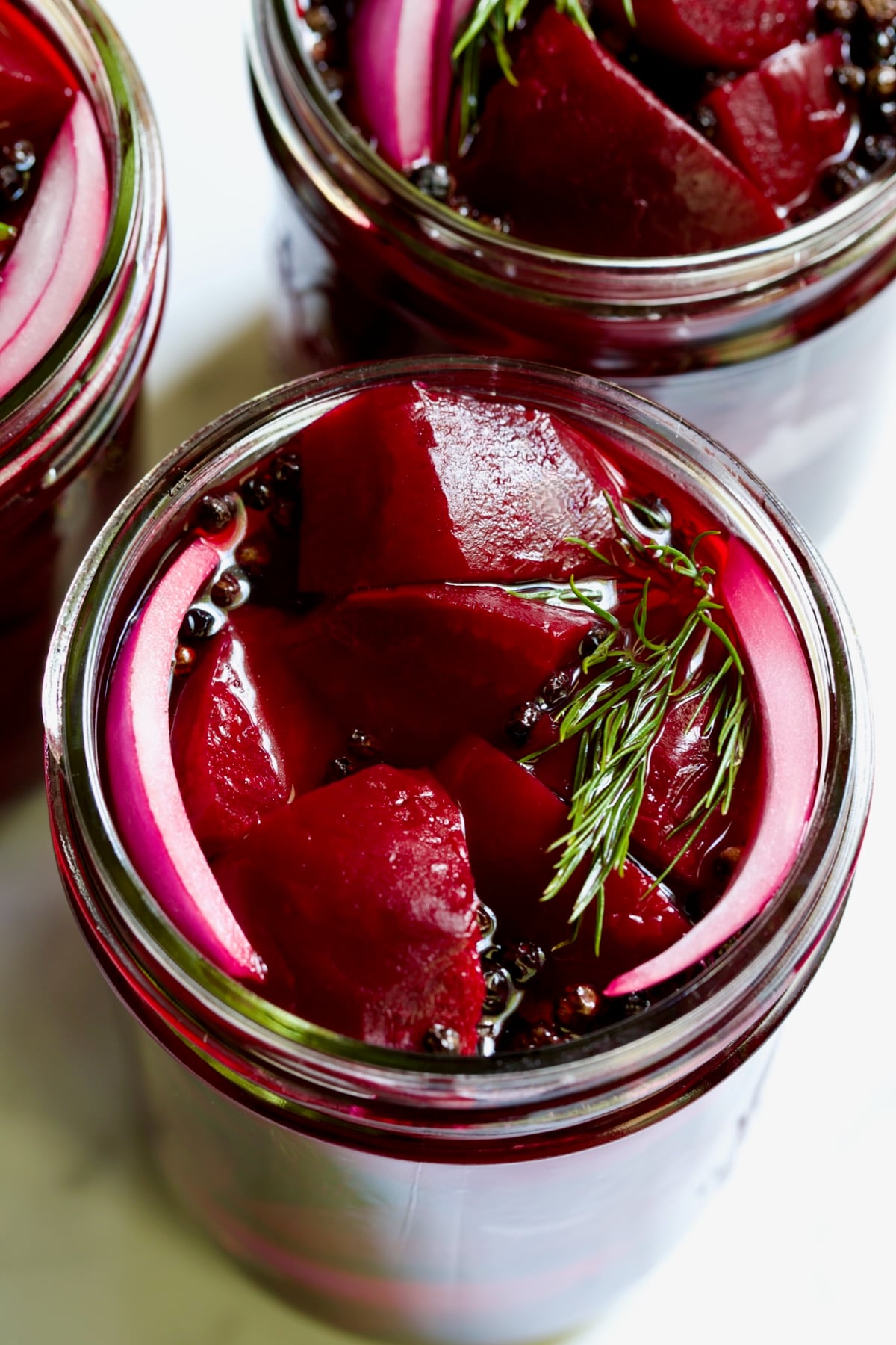 Fully filled pint jar with beets, dill, red onion and black peppercorns.
