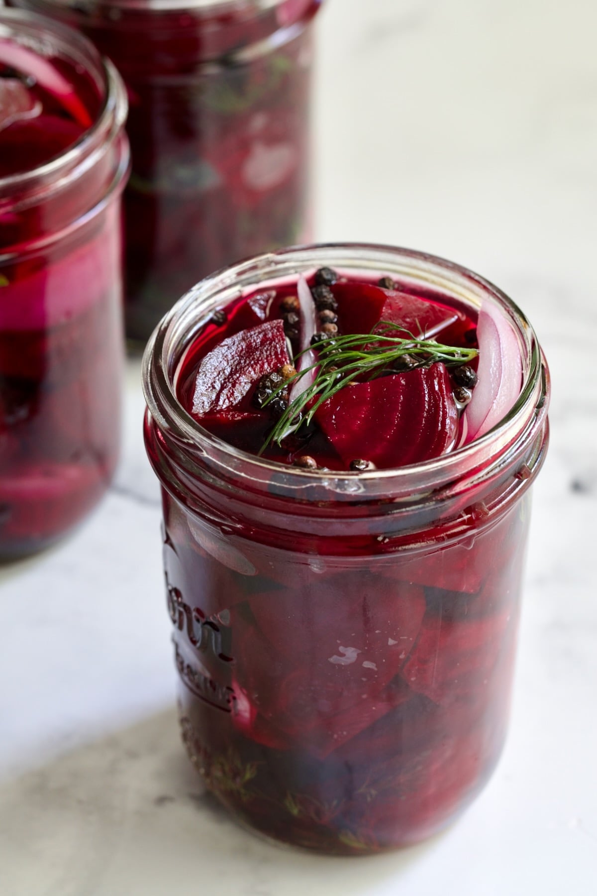 Fully filled pint jar with beets, dill, red onion and black peppercorns.