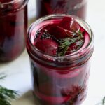 Fully filled pint jar with beets, dill, red onion and black peppercorns.