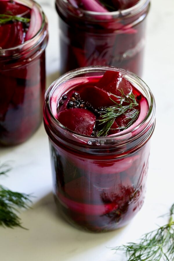 Fully filled pint jar with beets, dill, red onion and black peppercorns.