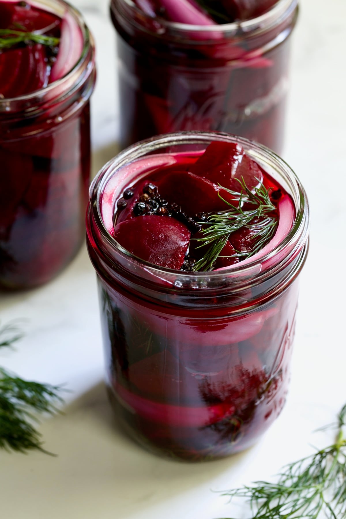 Fully filled pint jar with beets, dill, red onion and black peppercorns.