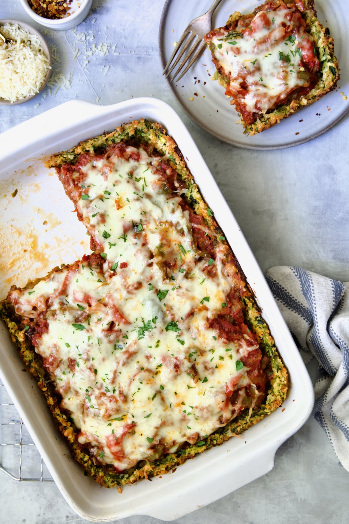 A piece cut from the Zucchini Pizza Casserole with it on a small round plate.