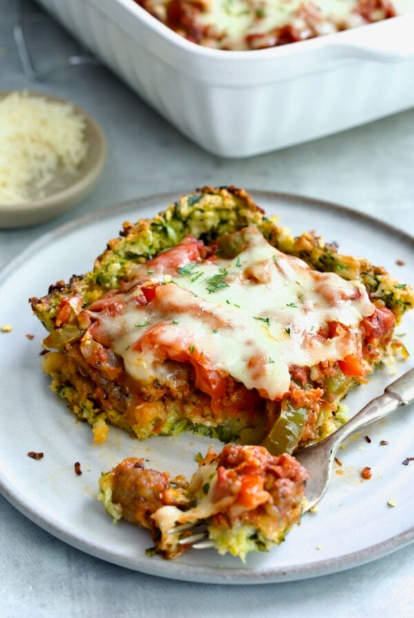 Piece of Zucchini Pizza Casserole on small plate with a piece on a fork.