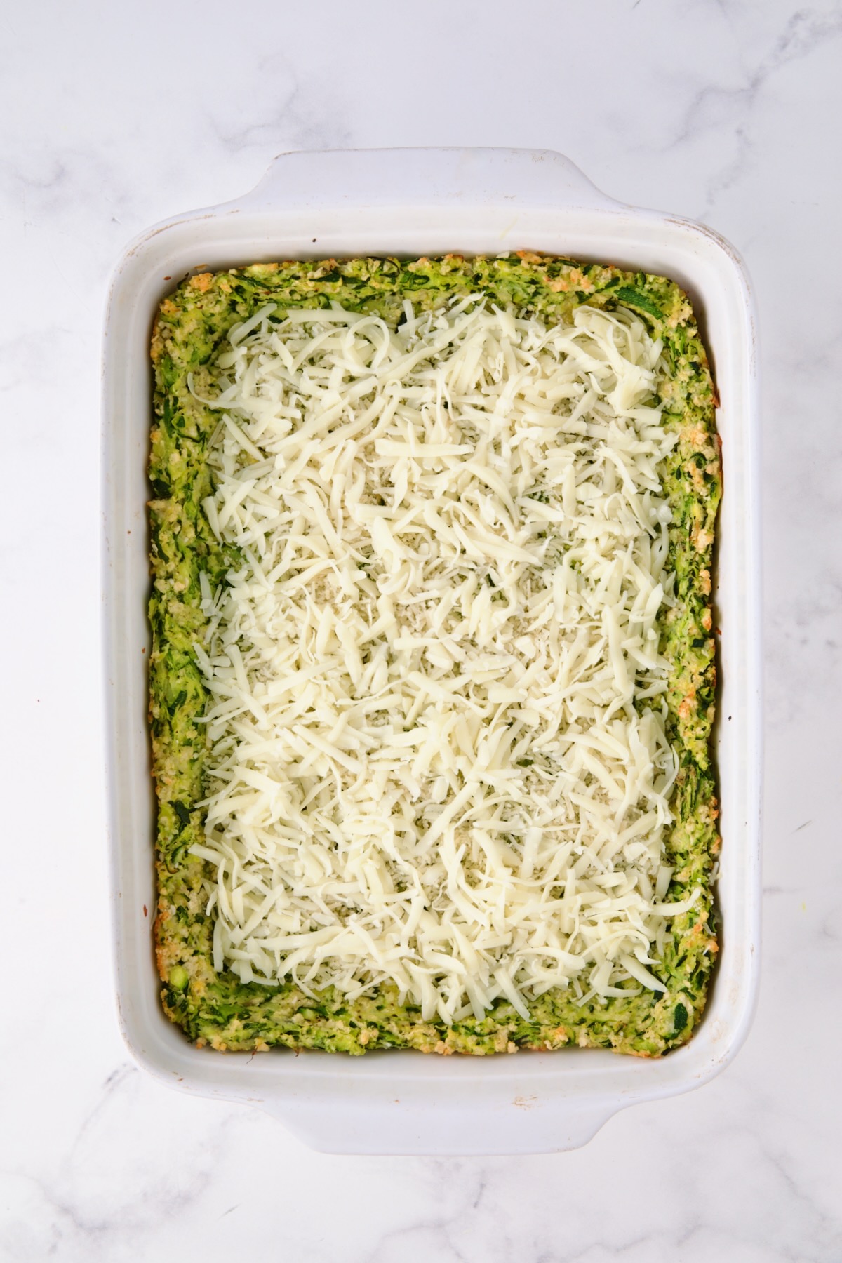 Layer of cheese over zucchini crust.