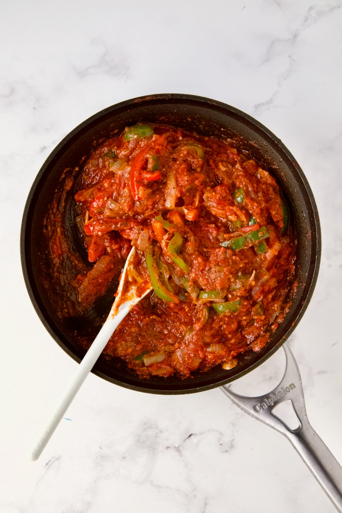 Crushed tomatoes, onions, and bell peppers in nonstick skillet.