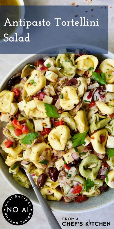 Pinterest graphic for Antipasto Tortellini Salad showing it in a white serving bowl with serving spoon.