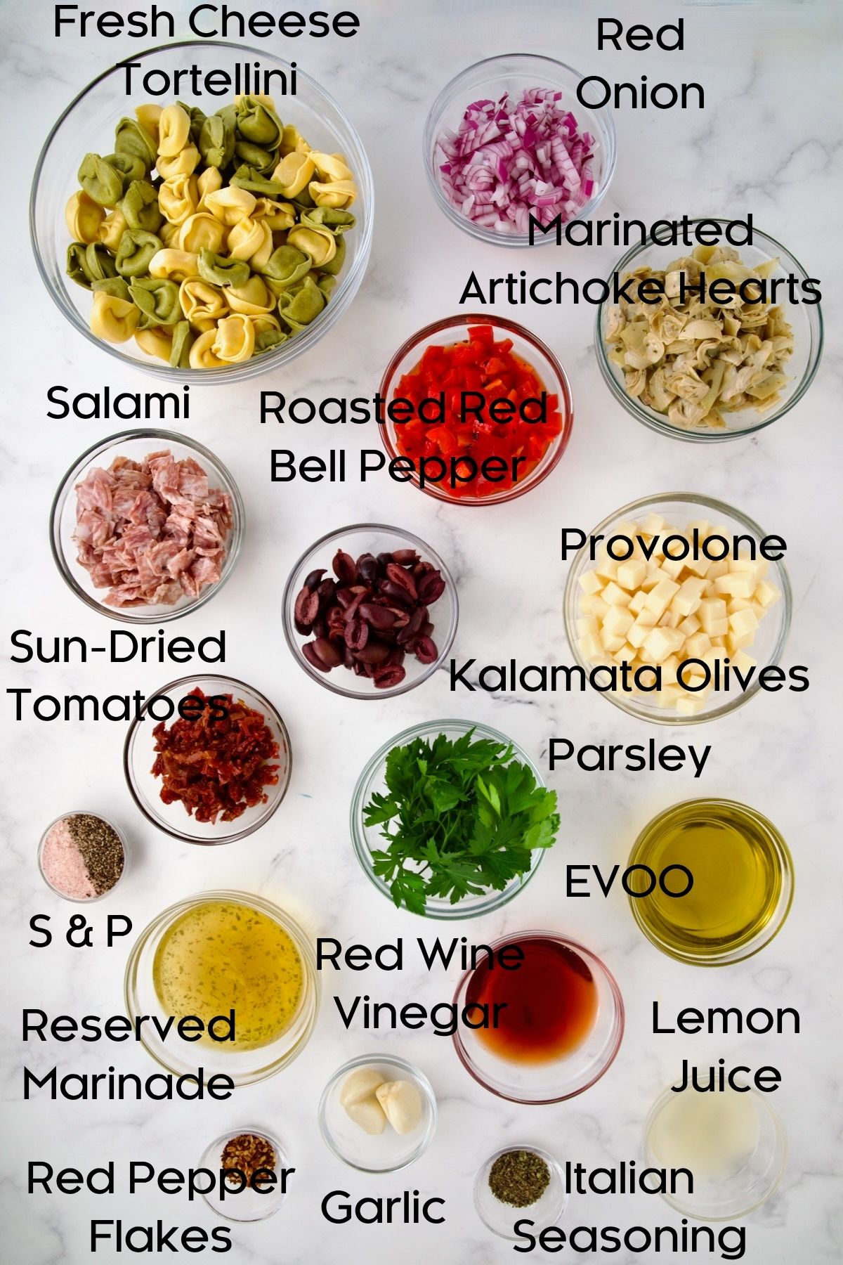 Ingredients for Antipasto Tortellini Salad in glass bowls.