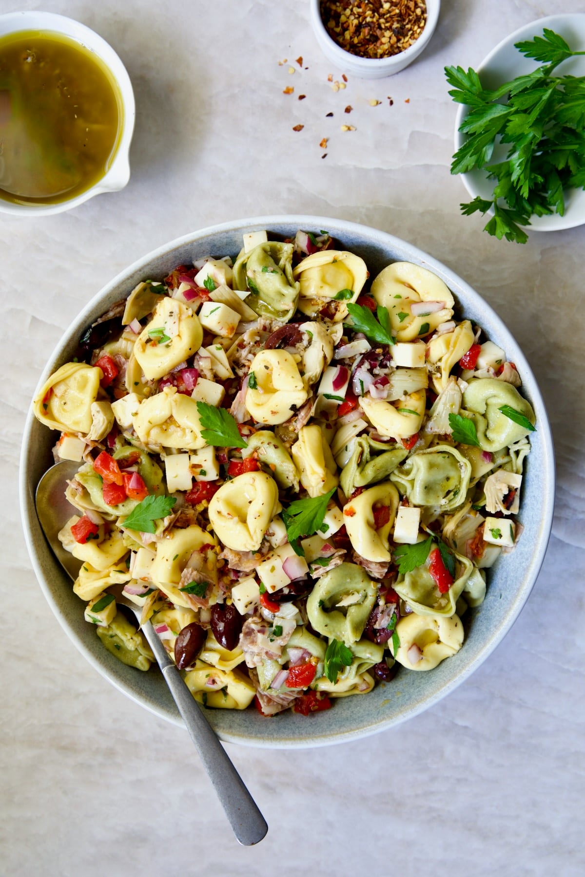 Antipasto Tortellini Salad in serving bowl with serving spoon.