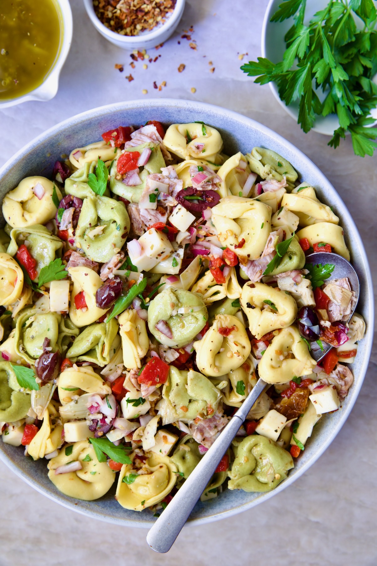 Antipasto Tortellini Salad in serving bowl with serving spoon.