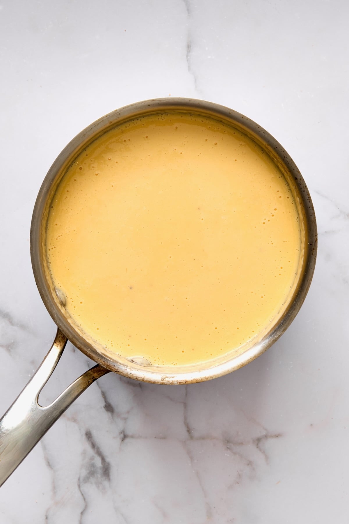 Cheese sauce in stainless steel saucepan.