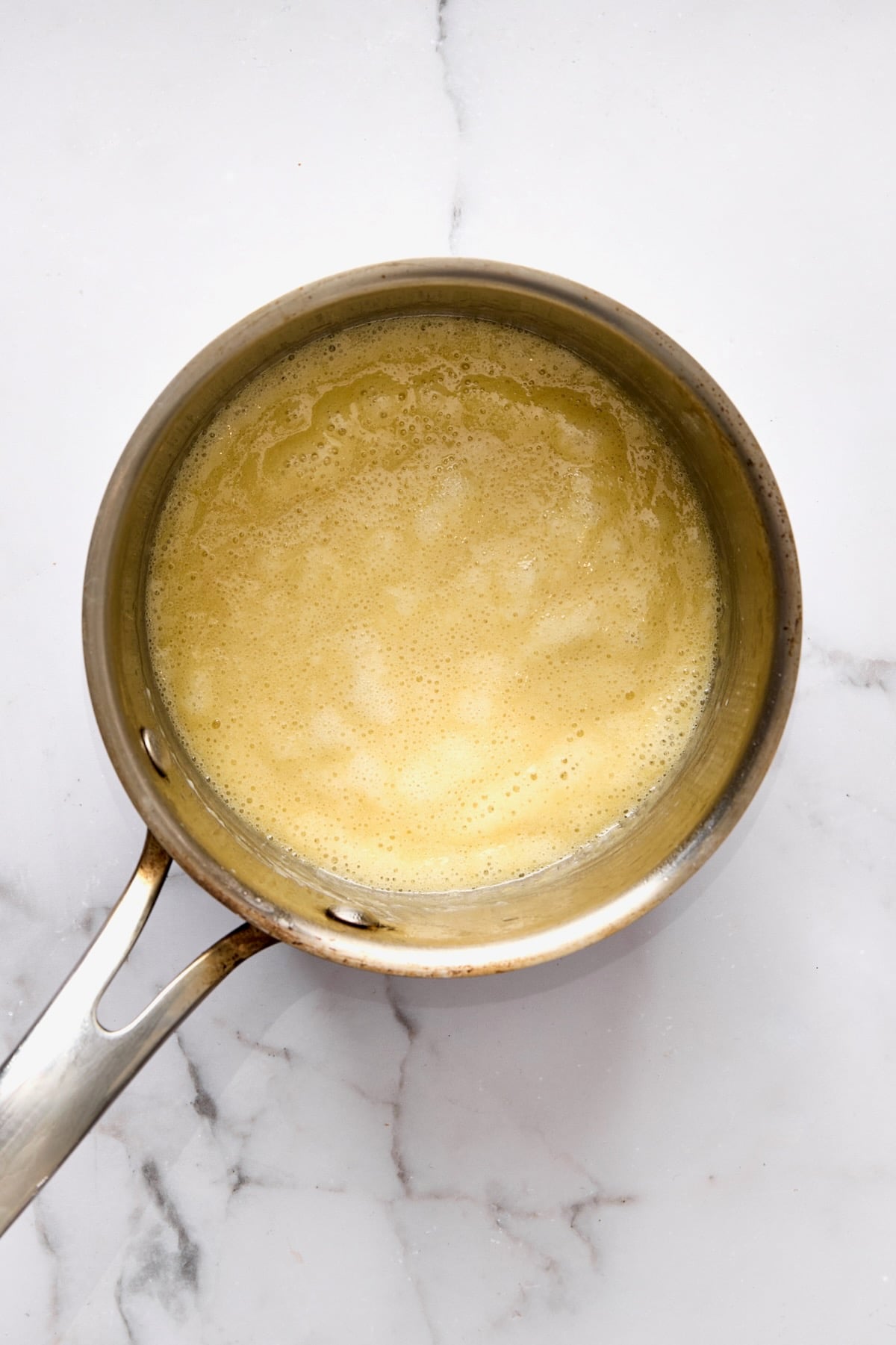 Butter and flour simmering in stainless steel saucepan.