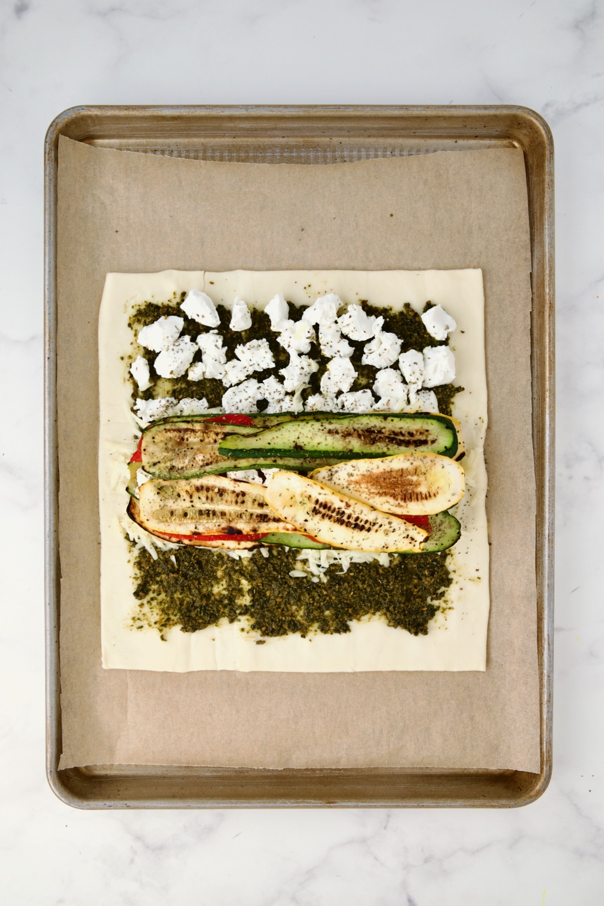 Final layer of zucchini and yellow squash placed over red bell pepper and goat cheese.