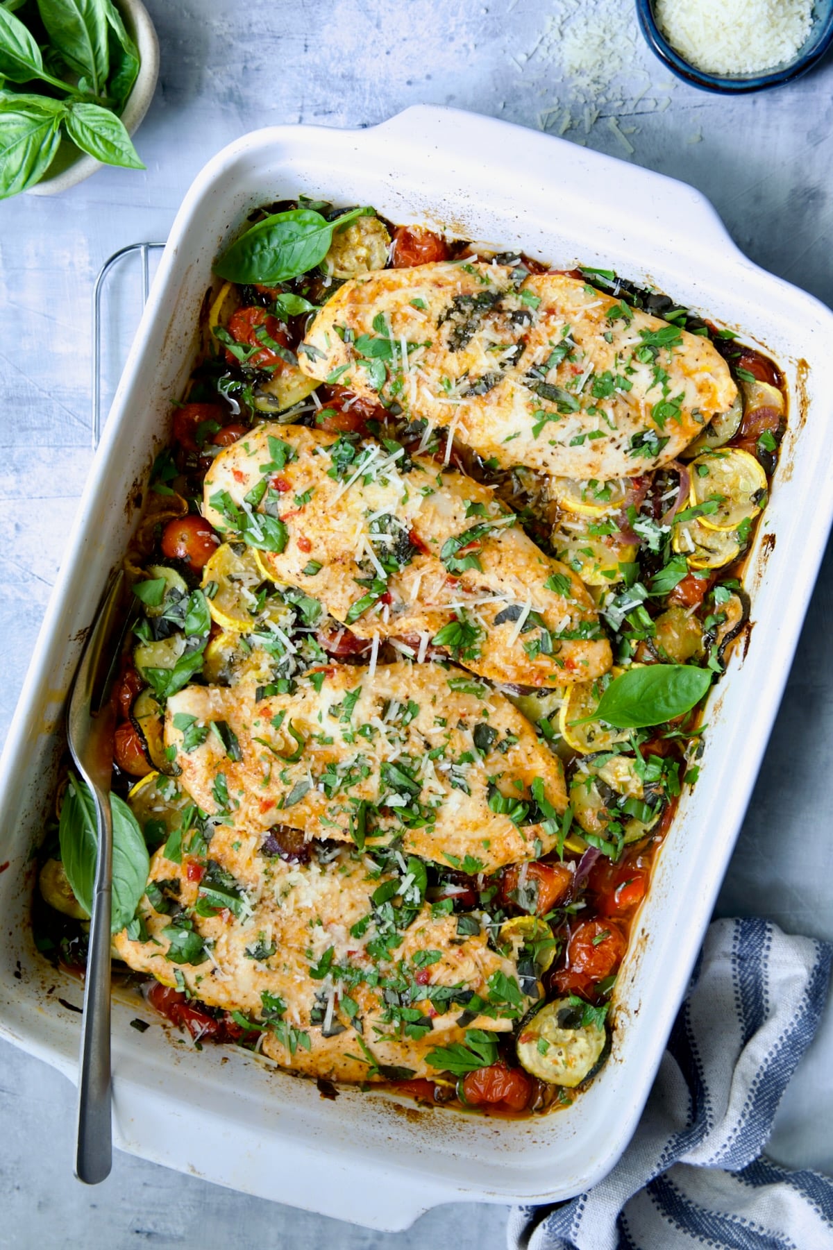 One-Pan Summer Vegetable and Chicken Bake in white rectangular baking dish.
