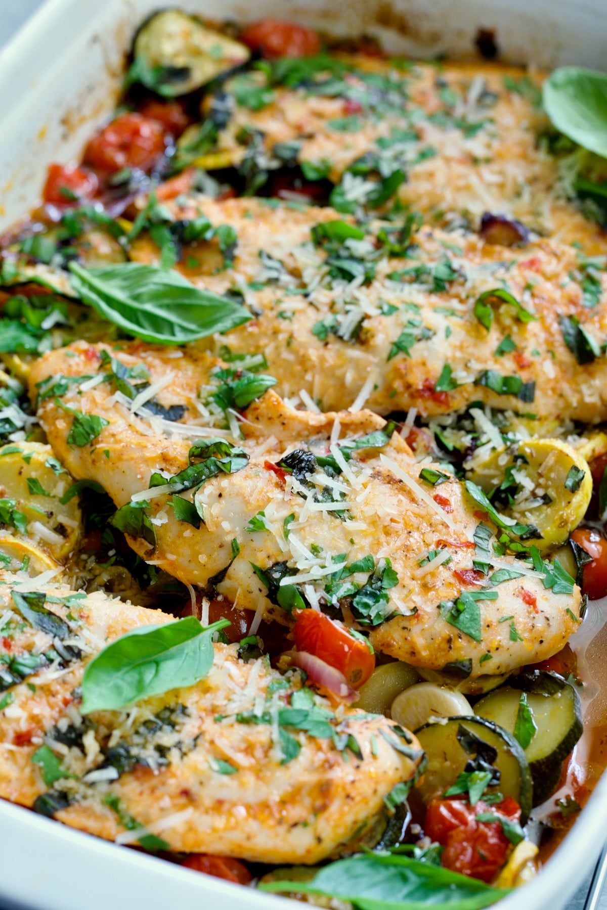 One-Pan Summer Vegetable and Chicken Bake in white rectangular baking dish.