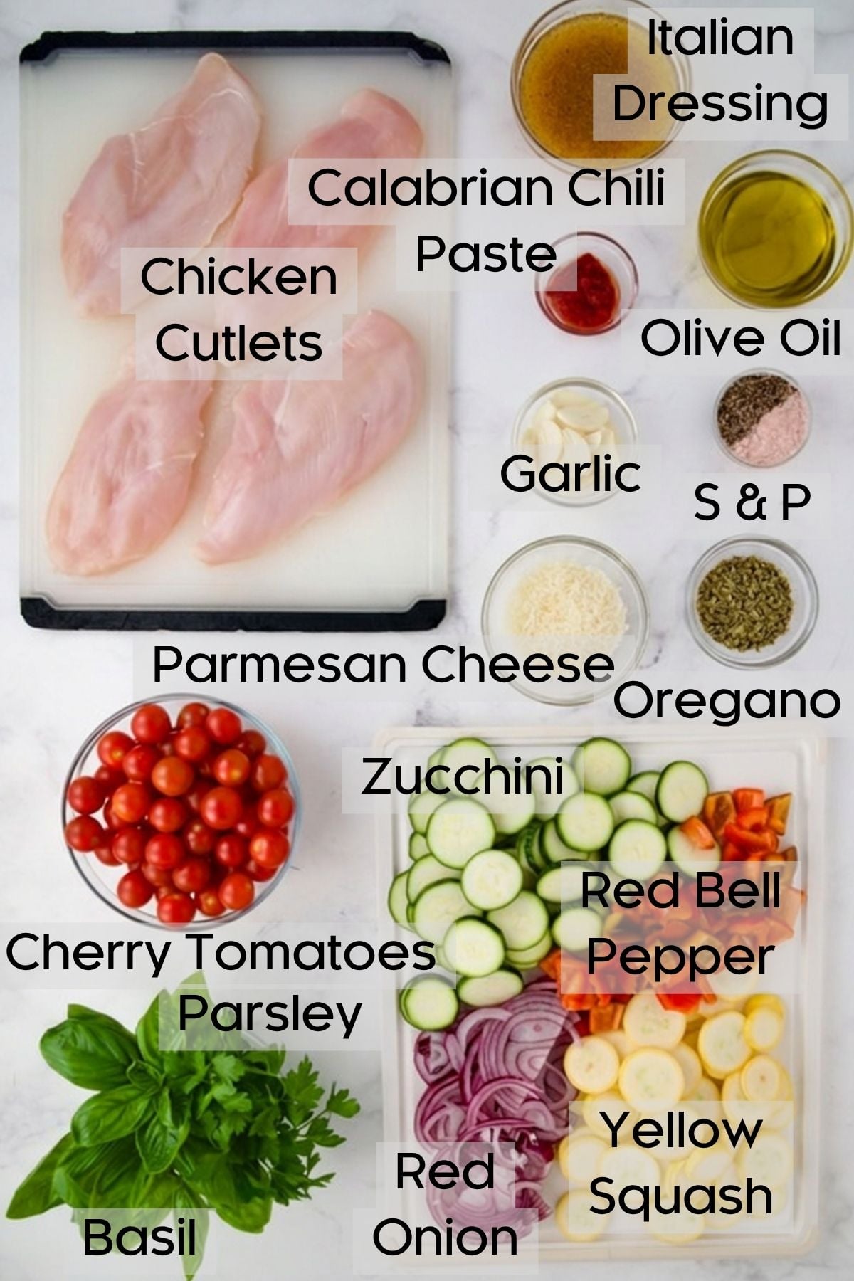 Ingredients for One-Pan Summer Vegetable and Chicken Bake on white plastic cutting boards and in glass bowls.