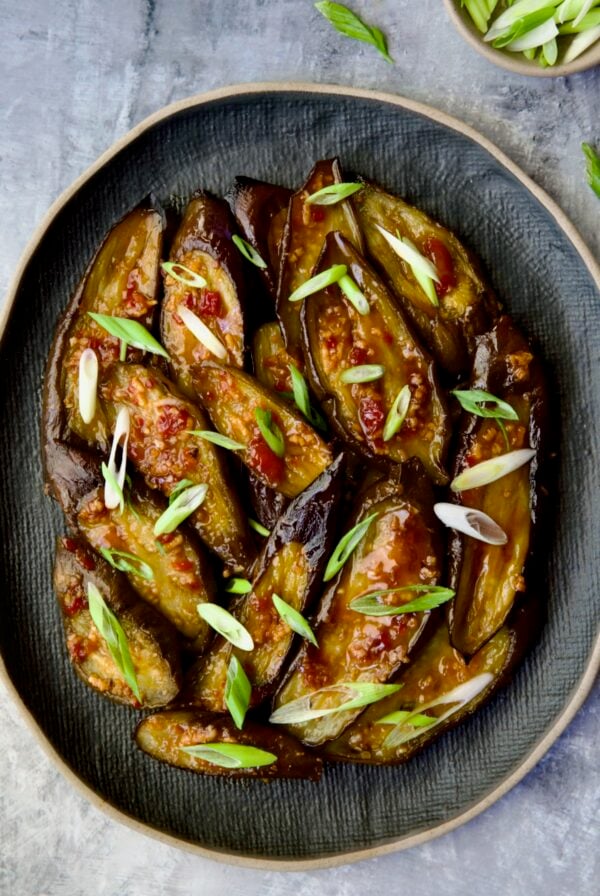 Thai Sweet Chili Eggplant on blue oval plate garnished with scallions.