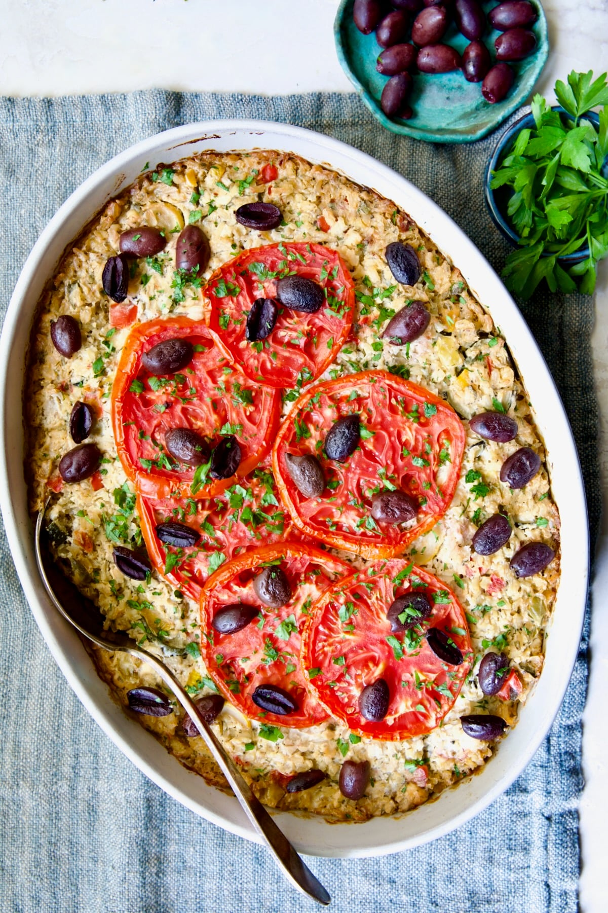 Greek Vegetable Casserole Recipe in oval baking dish with serving spoon.