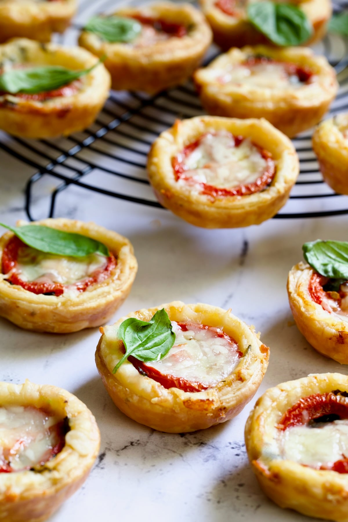 Mini Southern Tomato Pies on round black wire cooling rack.