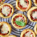 Mini Southern Tomato Pies on round black wire cooling rack.