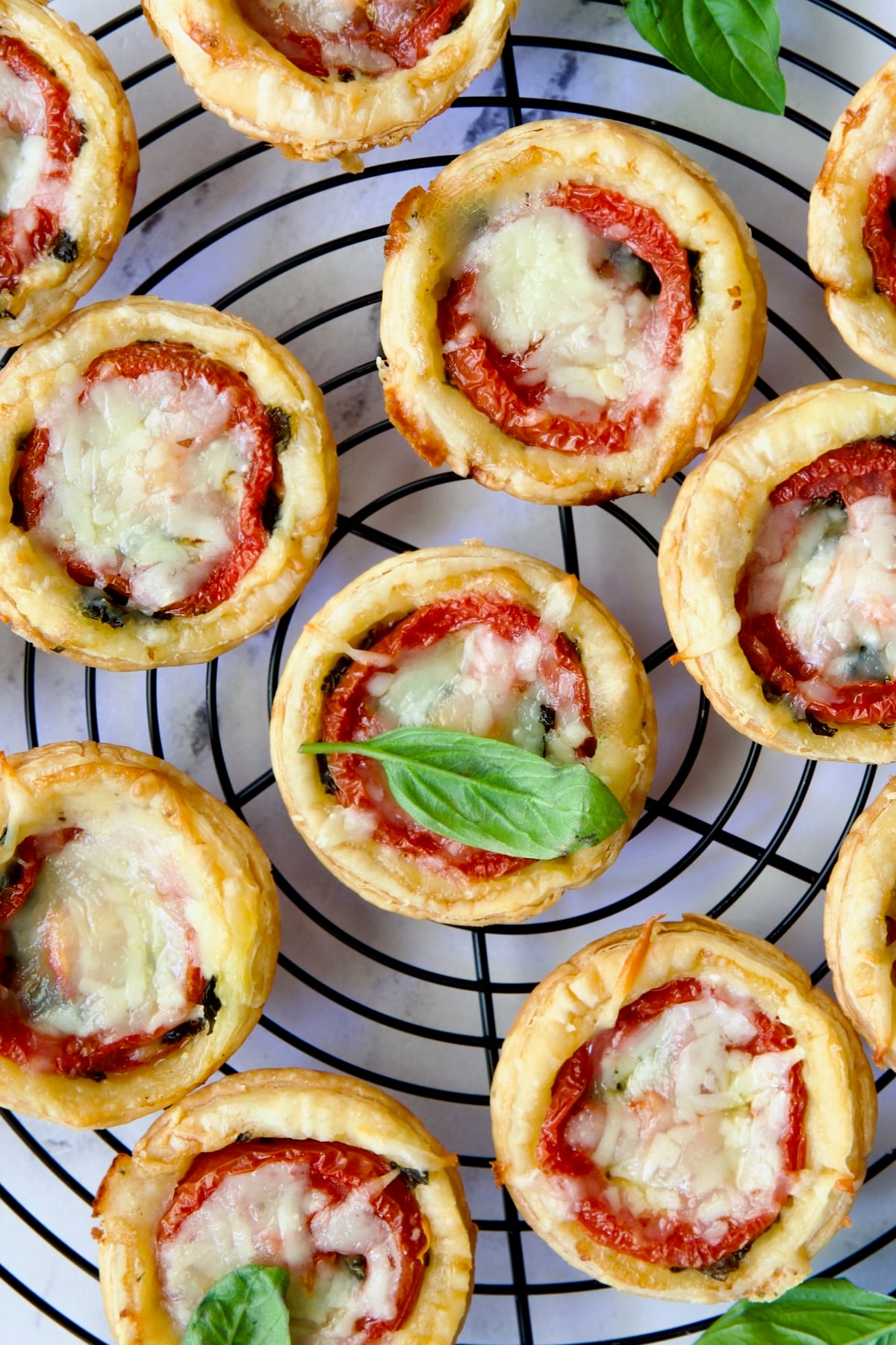 Mini Southern Tomato Pies on round black wire cooling rack.