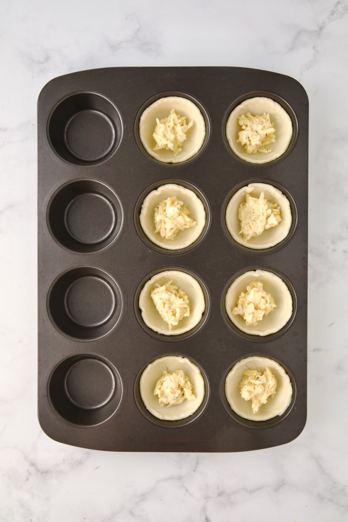 Mayonnaise and cheese mixture placed over puff pastry rounds in 8 cups of a 12-cup muffin pan.