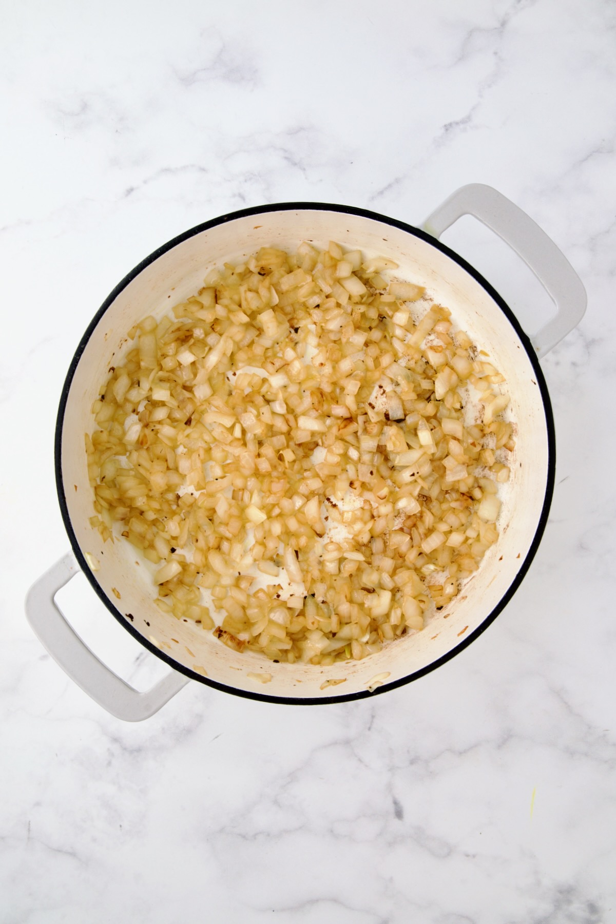 Sauteed onion in white enamel cast iron skillet.