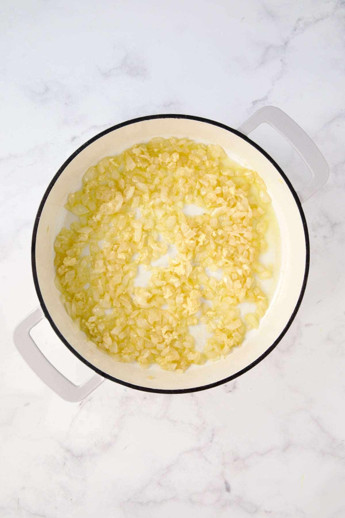 Cooked onions in white enamel cast iron skillet.