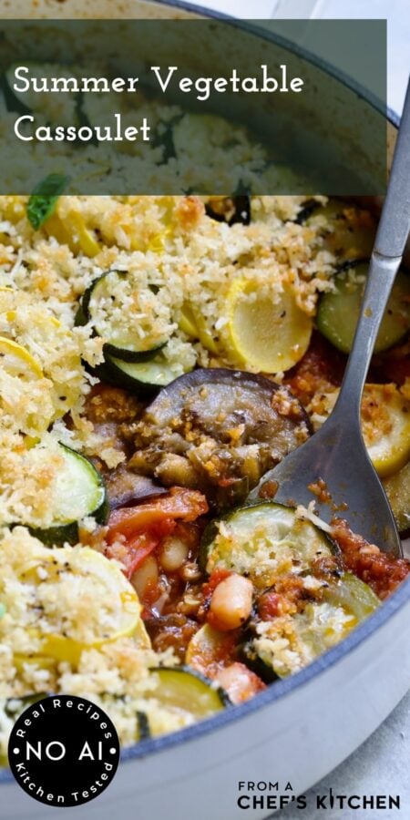 Pinterest graphic for Vegetarian Cassoulet showing it in a white enamel cast iron skillet with serving spoon.